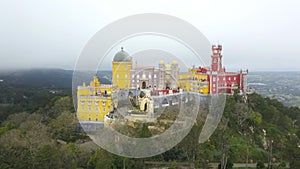 Aerial around view of Pena Palace Palacio da Pena in Sintra, Portugal. The palace is UNESCO World Heritage Site, shot from drone