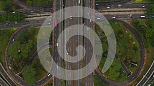 Aerial ascending birds eye close up overhead top down view of multiple vehicles on a multi lane road intersection on a