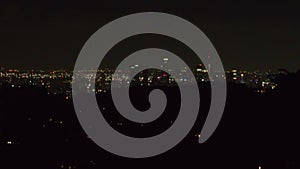 Aerial ascending footage of night city. Gradually revealing group of modern downtown skyscrapers. Los Angeles