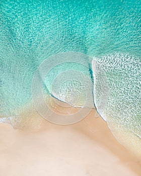 Aerial of a beach with beautiful waves, white sand and ocean textures