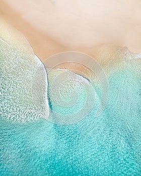 Aerial of a beach with beautiful waves, white sand and ocean textures