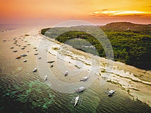 Aerial of a beach in Panglao Island Bohol. Late afternoon with several bancas docked.