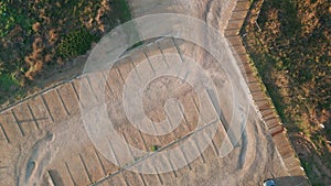 Aerial beachside parking lot in sunlight. Empty sandy terrain with cars outdoor