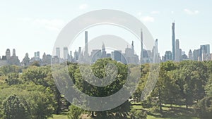 AERIAL: Beautiful Central Park view and Manhattan Skyline in Background at sunny summer day