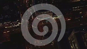 AERIAL: Beautiful Overhead Shot of busy intersection at night with Car traffic and city lights