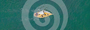 Aerial bird's eye view photo taken by drone of sailboat in turquoise sea water BANNER, LONG FORMAT