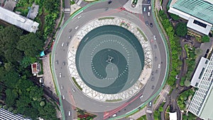 Aerial Birds Eye Overhead Top Down clock rotating View of busy city traffic in the Selamat Datang Monument roundabout at