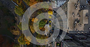 Aerial birds eye overhead top down view of street between urban development and park with autumn colour trees. Manhattan