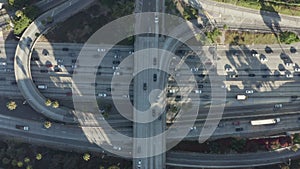 AERIAL: Birds eye view of Downtown Los Angeles, California intersection traffic with palm trees and Skyline blue sky and