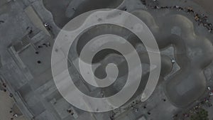 AERIAL: Birds View down on Venice Beach Skatepark with Visitors,Skaters and Palmtrees, Sunset Skating in Los Angeles