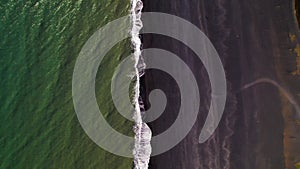 Aerial Black Sand Beach Fly Straight Over Ocean Waves Crashing Daylight. 4K High Quality Color Corrected