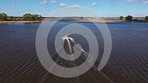 Aerial: A boat floating on a river. Water tourism by boat