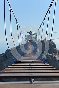 An aerial cable-stayed bridge hanging over an invisible chasm, with an accentuated spatial perspective.