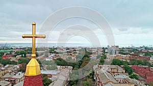 Aerial camera moving upwards revealing Christian Religious Cross over the city of Odessa. Religion concept.