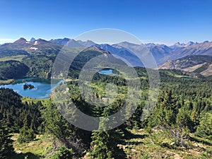 Aerial of the Canadian Rockies mountain range under a clear blue sky.