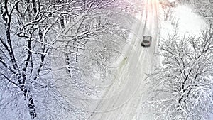 Aerial. Car on a rural snowy country road.