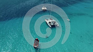 Aerial of Caribbean turquoise waters approaching the Curacao beach where people are vacationing