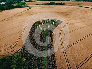 Aerial of a cereal field and the ruins of an old stone building, reminiscent of Stonehenge.