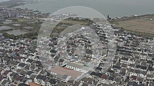 Aerial of a Chinese old fishing village, with wooden fishing boats in the harbor