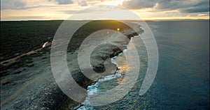 Aerial cinematic of calm swell on Curacao north coast during sunset on a cloudy day