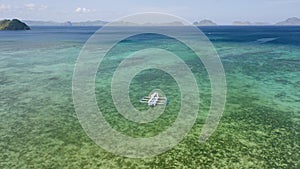 Aerial circle footage of Filipino boats moored in shallow lagoon bay near El Nido village. Bacuit Bay, Palawan