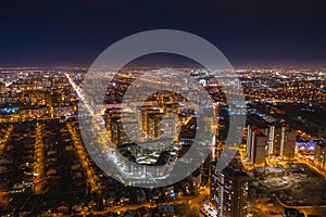 Aerial cityscape panoramic view, flight on drone above night city Voronezh with illuminated roads and high-rise buildings