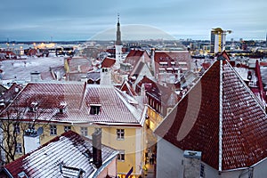 Aerial cityscape view of Tallinn Old Town in winter day. Red rooftops from tiles, Golden Cockerel weathervane, church spire,