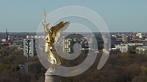 AERIAL: Close Up Circling around Berlin Victory Column Golden Statue Victoria in Beautiful Sunlight and Brandenburg Gate