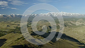 Aerial close up - Female hiker proudly standing on mountain in summer. Young woman with a red backpack standing on top