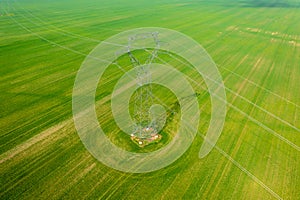 Aerial close-up view of electricity pylon with power lines over agricultural field