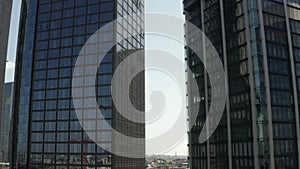 AERIAL: Close Up View of Skyscraper construction site in Urban environment with city car traffic and reflections in