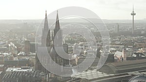 AERIAL: Cologne Hohenzollern Bridge and View on Cathedral with Central Train Station in beautiful hazy Sunlight