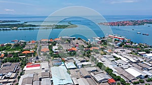 Aerial container terminal of Benoa Harbour with stacks of the boxes and a red command tower under light blue sky