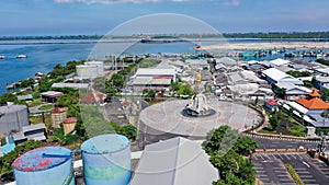 Aerial container terminal of Benoa Harbour with stacks of the boxes and a red command tower under light blue sky