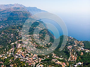Aerial daytime view of Sorrento coast, Italy. Streets of city with hotels and restaurants are located on rocky seashore, mountains