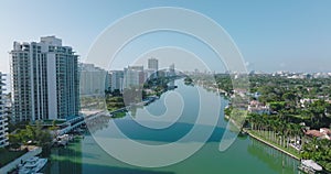 Aerial descending footage of luxury residential borough in tropical area. Buildings on creek waterfront. Miami, USA