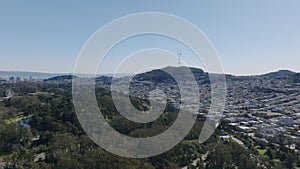 Aerial descending footage of rows of residential houses in Sunset district. Revealing trees in Golden Gate Park. San