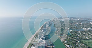 Aerial descending footage of sea coast in city. Row tall apartment buildings in luxury residential borough. Miami, USA