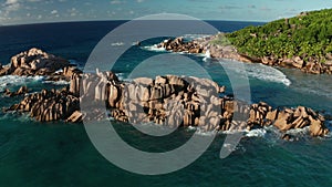 Aerial dolly and lift up over shore and gulf Grand l`Anse, La Digue
