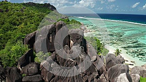 Aerial dolly slowly over black granite boulders of jagged smooth shape