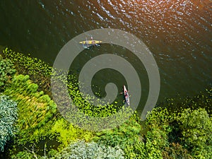 Aerial drone bird`s eye view photo of Happy family with two kids enjoying kayak ride on beautiful river. Little boy and