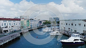 Aerial drone camera moves along Constitution River with yachts Bridgetown, Barbados