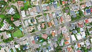 Aerial drone, city and houses with road of traffic in urban settlement above architecture or buildings. Top view of