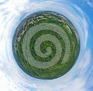 Aerial drone 360 degree panoramic view on green lungs forest surrounding european city during summer, aquapark complex