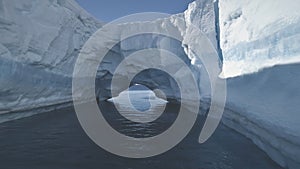 Aerial drone flight to Antarctica iceberg arch.