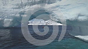 Aerial drone flight to Antarctica iceberg arch.