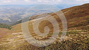 Aerial drone fly over active woman by tent on top of summer mountains.