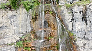 Aerial Drone Flying Down Tall Rocky Mountain Waterfall