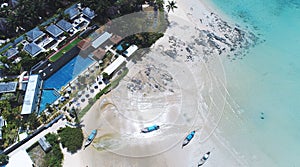 AERIAL. Drone flying under the amazing tropical bay with clear water, white beach and traditional longtail boats
