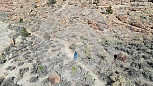 Aerial drone follow Woman hike desert mountain Canyon Utah 4K